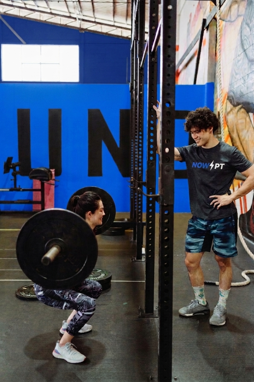 Personal trainer coaching a client at the gym
